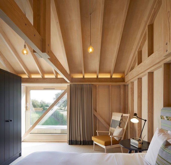 The expressed timber structure suggests agricultural buildings, but is  luxuriously reinterpreted.