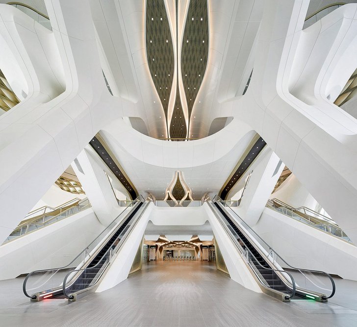 Escalators echo the canted uprights of the concrete frame.