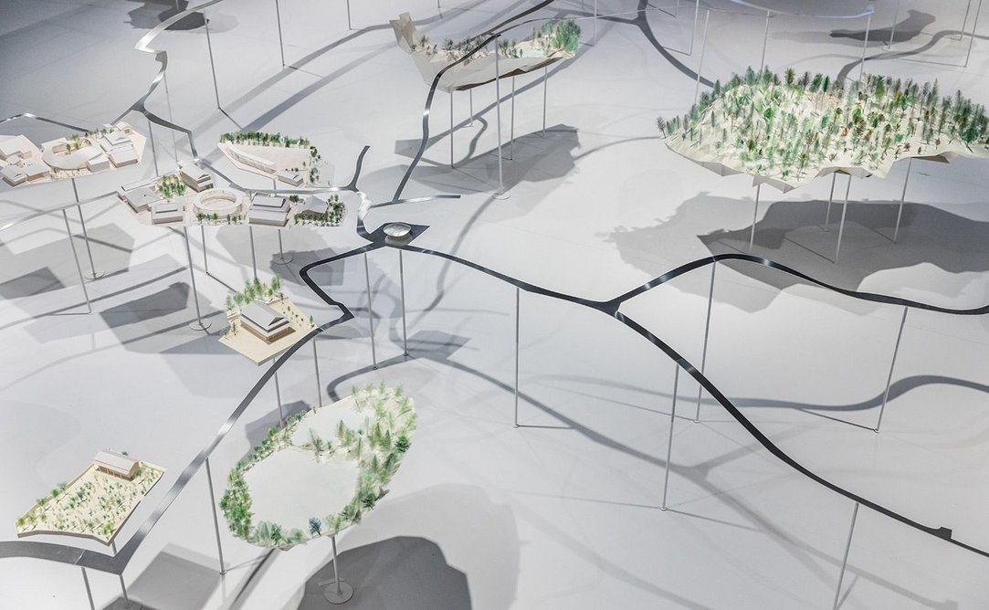Installation detail of Symbiosis – Living Island, an exhibition about the Inujima Art House Project, at Japan House London. Designed by Kazuyo Sejima & Associates, the central model shows key intervention sites on the island.