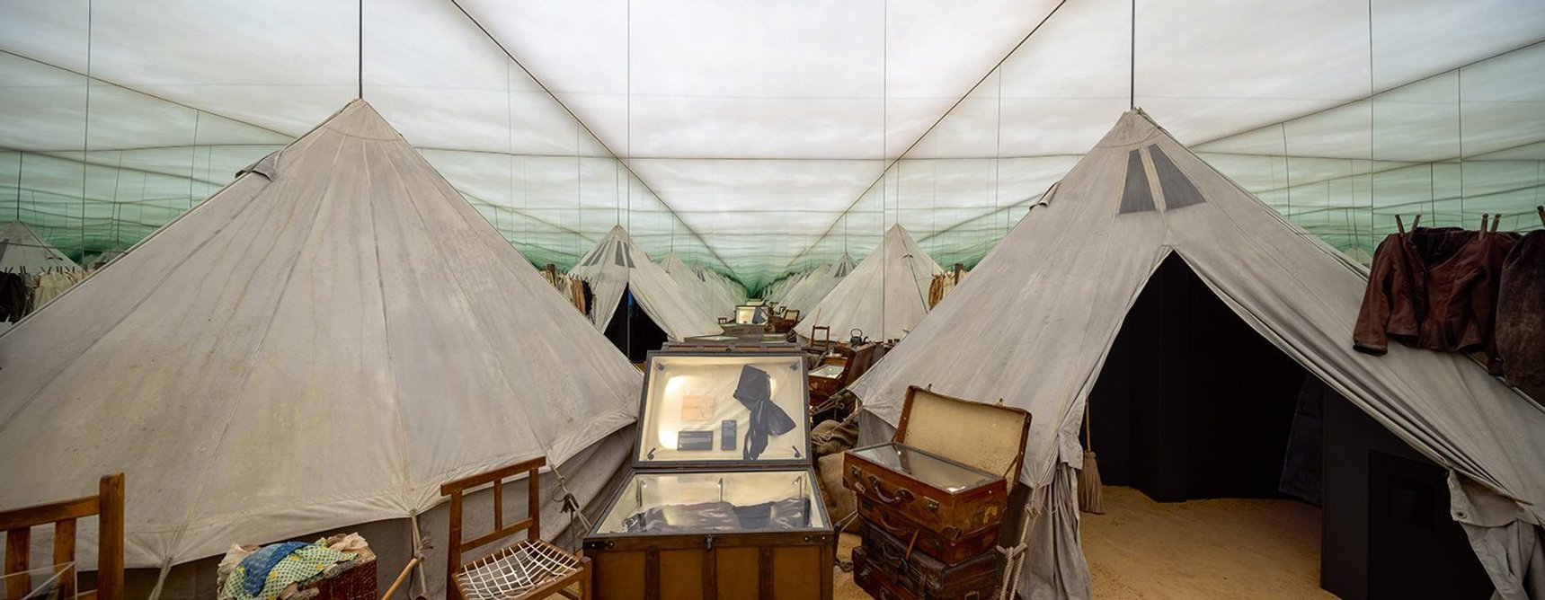 Mirrors are used to give a sense of scale to the exhibition of concentration camp tents.