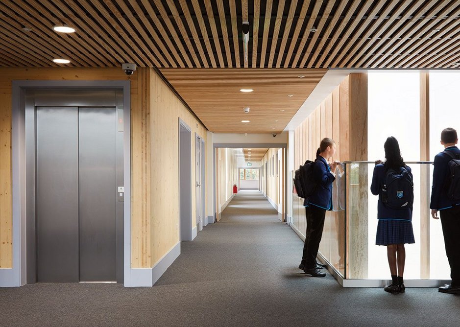 Students can look down into the triple-height library from the timber-lined corridors.