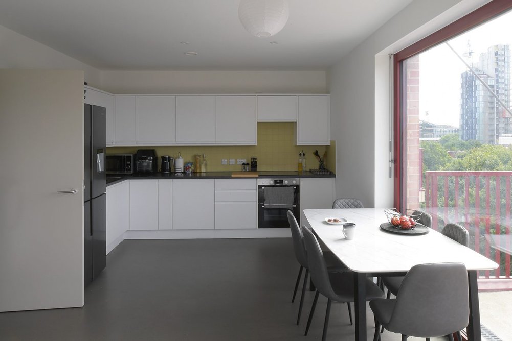 An upper apartment kitchen with dining area and sliding doors to the generous balcony. Each apartment is for social rent.
