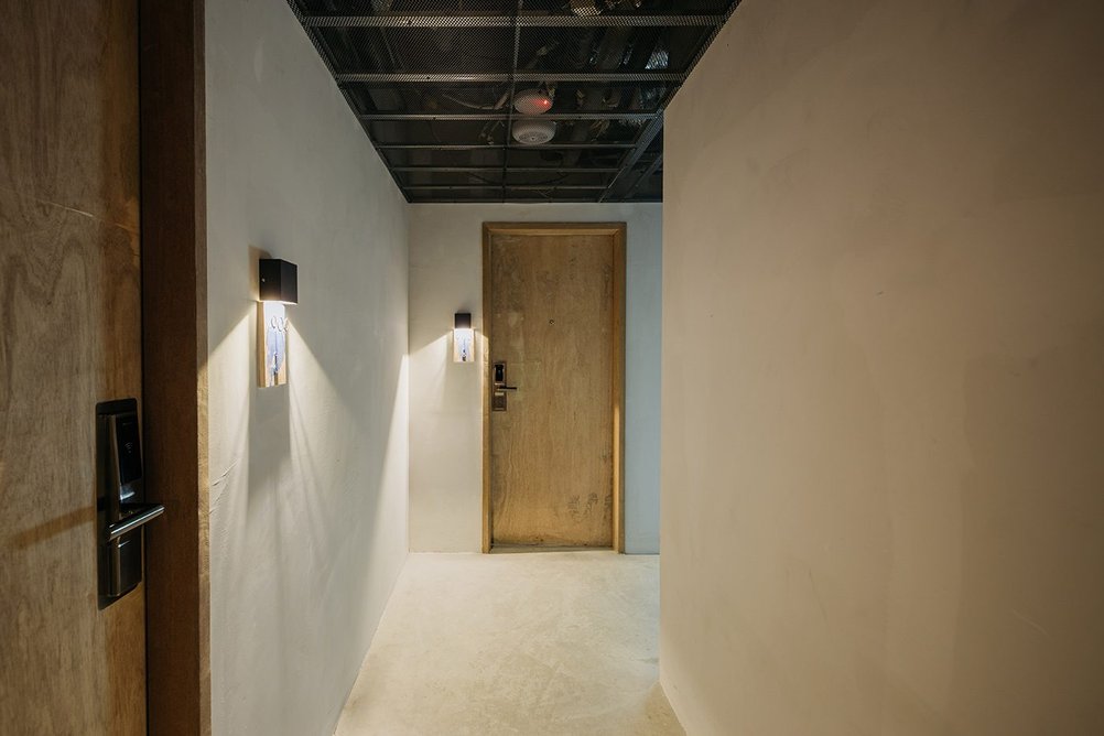 One of the hotel bedroom corridors with its original doors sanded down and walls plastered using lime plaster - more of a gallery feel.