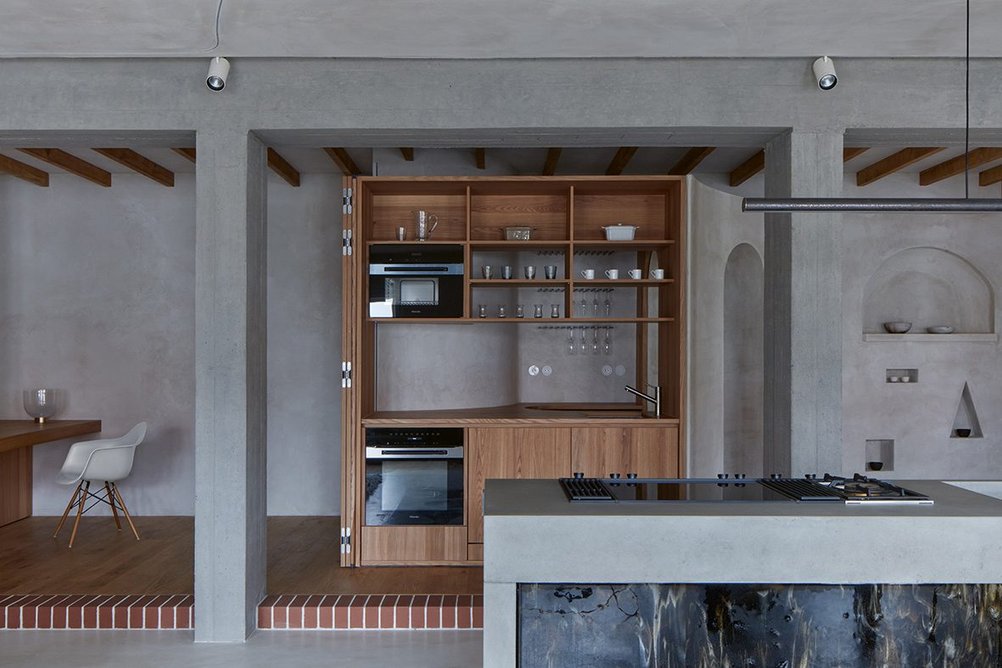 A timber 'wall' folds open to reveal the hidden half of the kitchen.