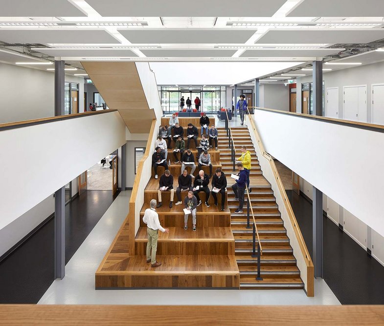 The oversized steps of the central atrium act as an informal social space, leading down from the lobby to the canteen.