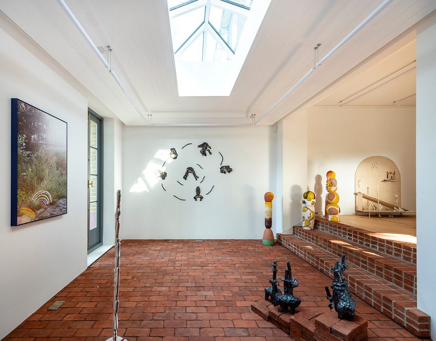 The main lower gallery in the ground floor extension has a skylight and terracotta brick floor.