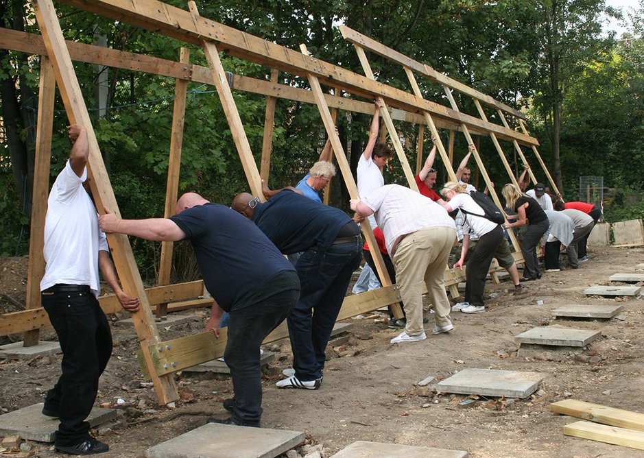 Volunteers get to work raising the frames of the reconfigured building.