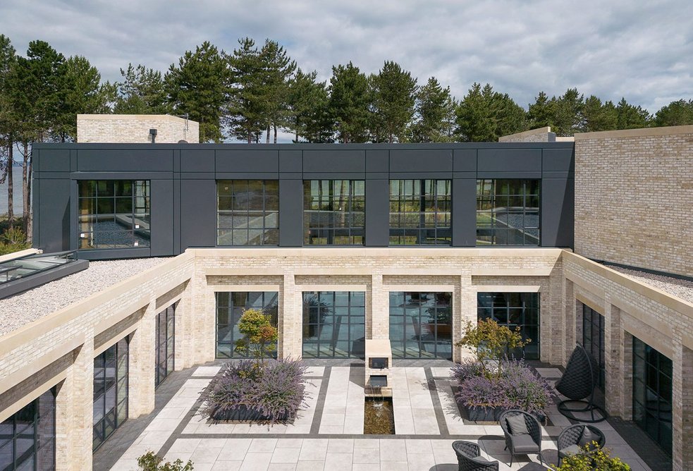 Uniform geometric brick and glazed facades bounce light into an internal courtyard.