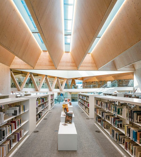 Reading floors spin off a large triangular circulation atrium linking the library’s five levels. Hybrid timber trusses span between mass timber cores.