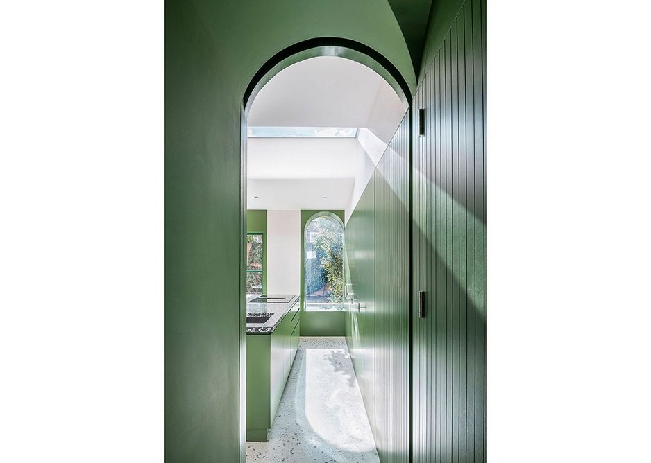 Copious amounts of storage are hidden behind green-painted, timber doors; their grooves suggest the fluting of pilasters.