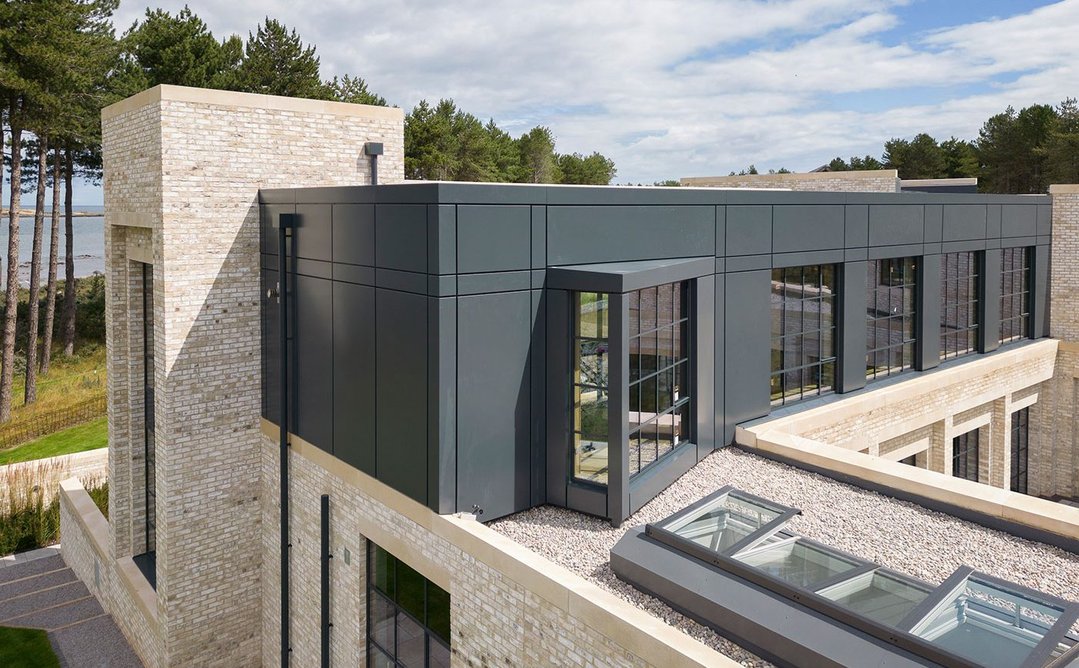 Anvil metal cladding on the first floor contrasts with the brightness of the main facade.