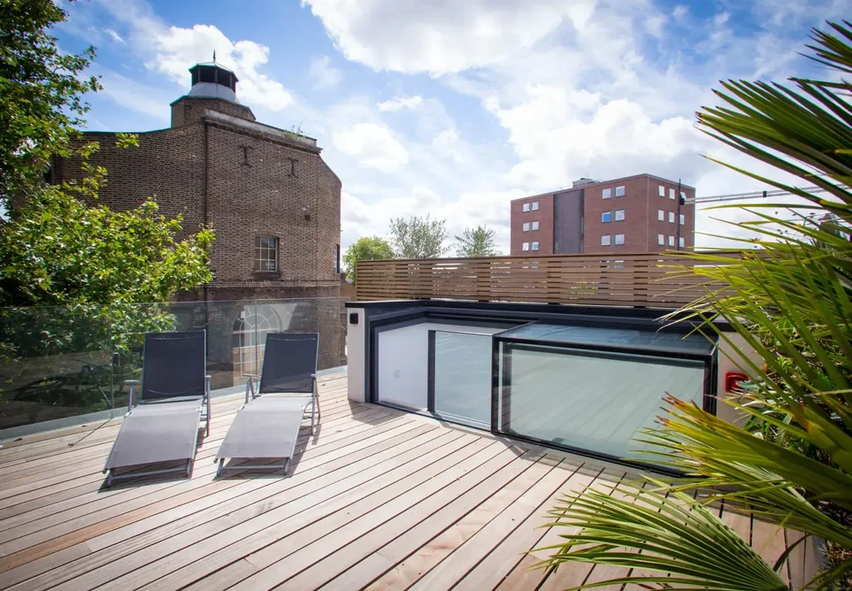 A three-wall boxed rooflight provides elegant access to the roof terrace of a modern townhouse.