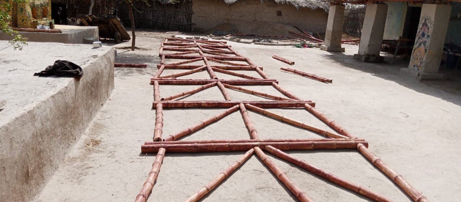 Prefab bamboo panels laid on ground before being erected.