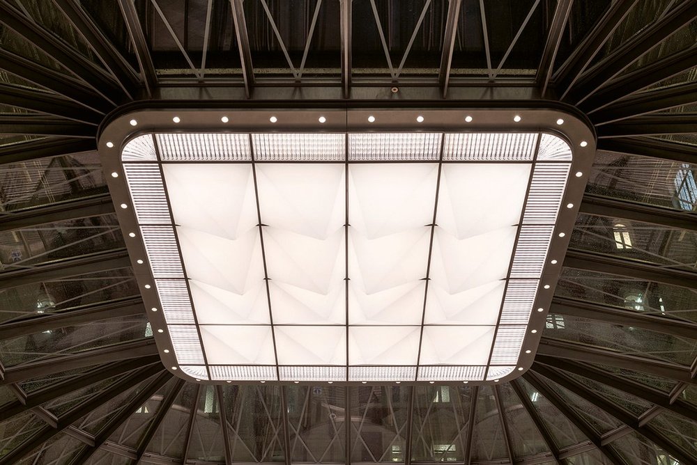 In the entrance pavilion, the grid of pyramids is set in a shimmery glass border, surrounded by perimeter spotlights.