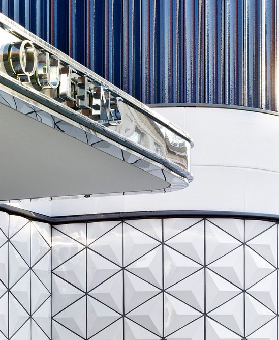 Extruded NBK terracotta panels contrast with a plinth of triangular cast tiles at Queens, a residential conversion of an Art Deco cinema in Bayswater, London.