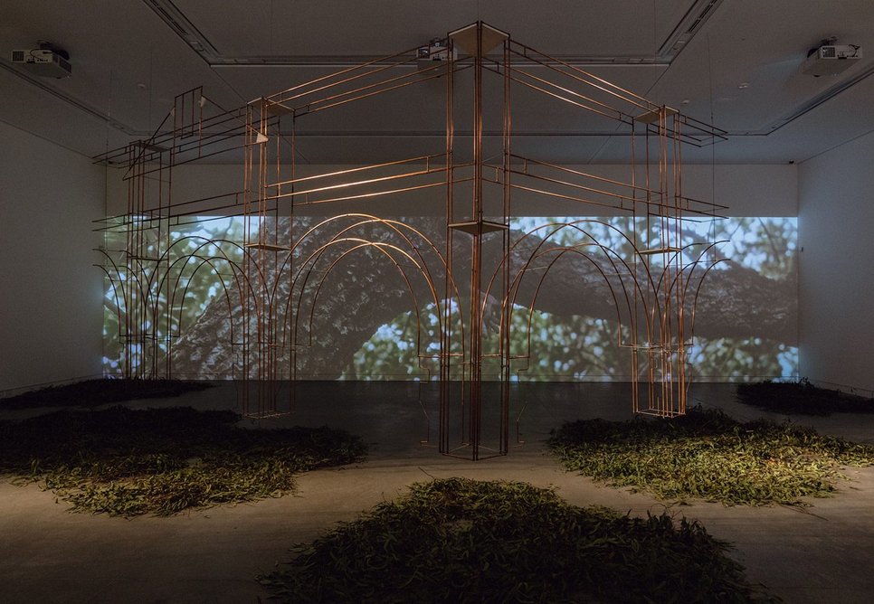 At the Australian pavilion, which probes the legacies of British rule, a skeletal copper fragment of the Empire Hotel in Queenstown hangs in the half-light above drifts of vegetation.