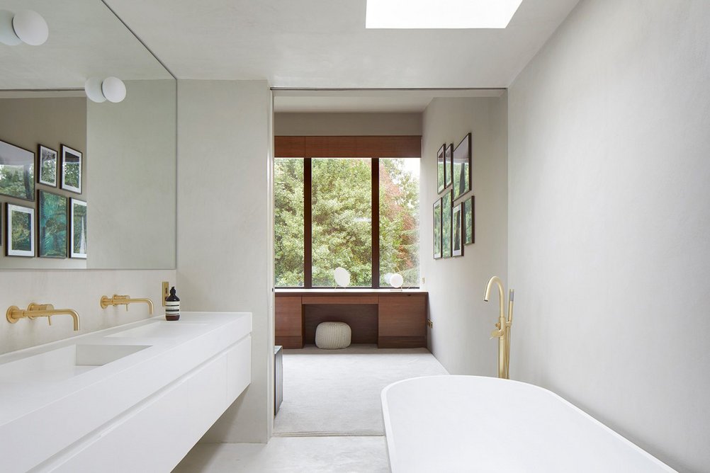 Bathrooms use microcement floor and wall finishes for a homogenous feel.
