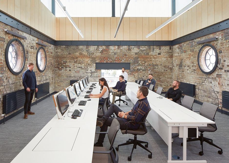 The upper level study space, with porthole windows and profiled glass lantern, acts as a beacon for the campus to the city.