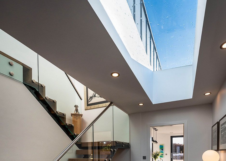 A flat glass fixed rooflight in the hallway opens up to the blue zinc cladding on the first floor, which harmonises with the roofs of neighbouring properties.