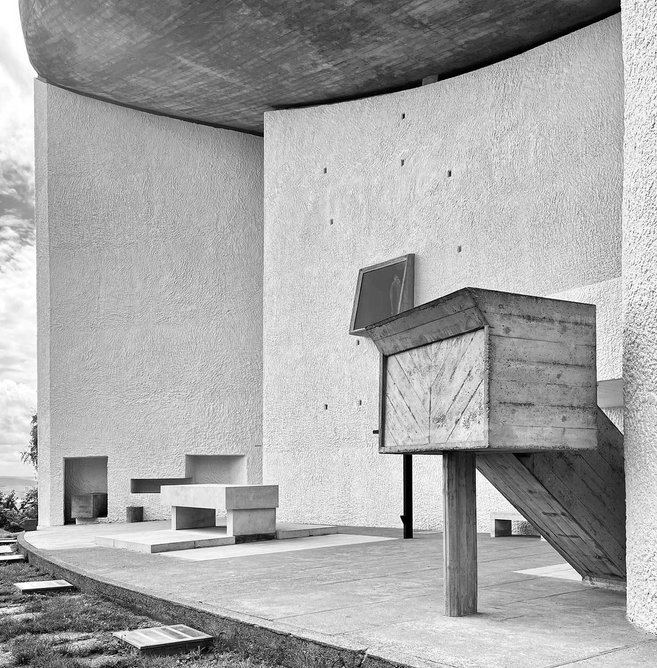 An exterior altar and pulpit are framed by the exposed béton brut concrete roof and north wall.