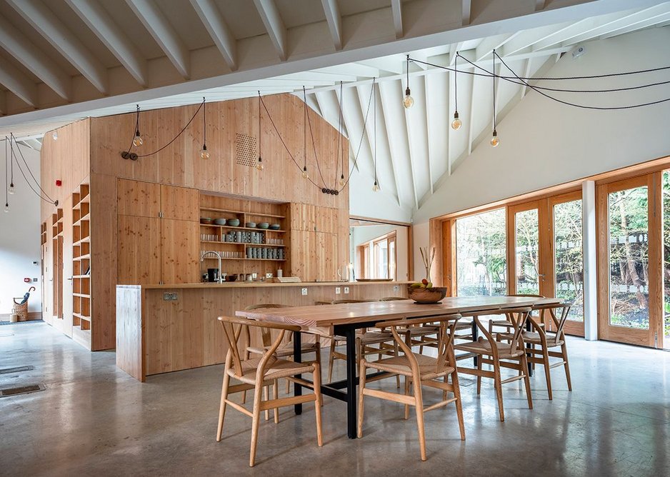 Exposed rafters rest on white painted steels about the CLT walls giving a lofty space above the Maggies’ kitchen table.