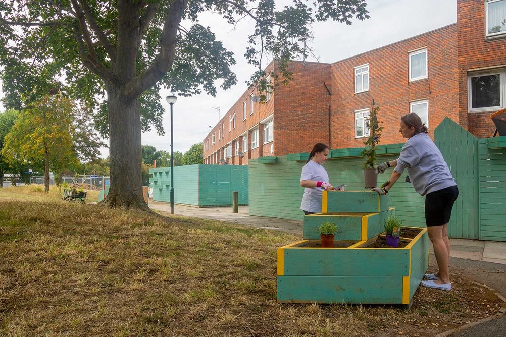 Residents getting involved in planting. To the rear, new fencing includes planters and a gate, giving direct access to Claridge Way.