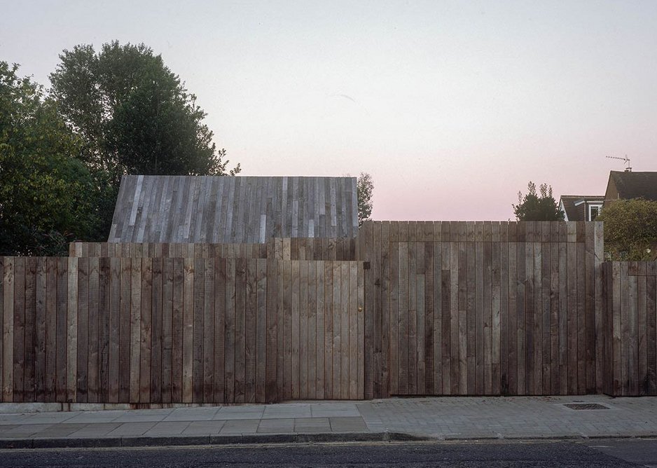 From the street the house appears as layers of timber fencing.