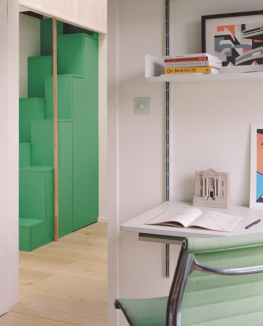 A bright green stepped ladder stair leads to the attic room.