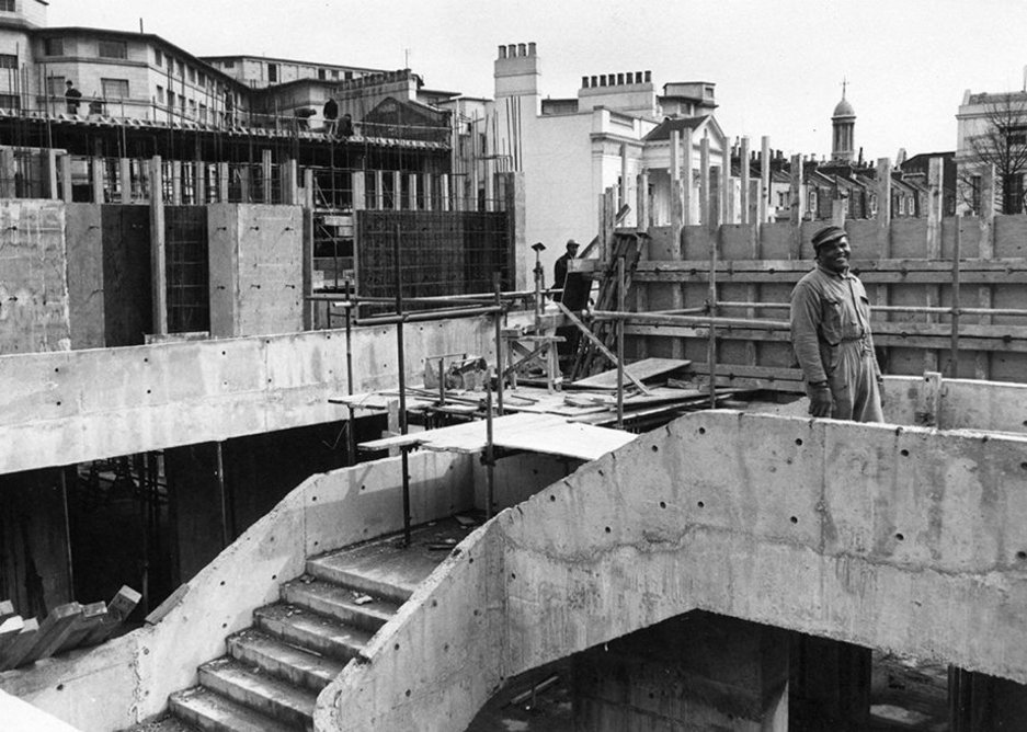 RCP construction works   Lasdun’s ambitious design for the RCP presented major engineering challenges. He wanted to extend the Dorchester Library outwards, so that it appears to ‘float’ unsupported above the main entrance.   This was achieved through cantilevers (horizontal beams extended into the main building to balance the weight of the library), 49 ft concrete beams, reinforced steel rods, and the three thin pillars at the entrance.   The RCP building is predominantly made of concrete, poured on site into wooden moulds. A lot of steel was used within the concrete, often tightened once the concrete had set but before the moulds were removed, to maximise its strength and help support Lasdun’s large rooms. The rough concrete was then clad in either mosaic tiles and engineering bricks, or left exposed.