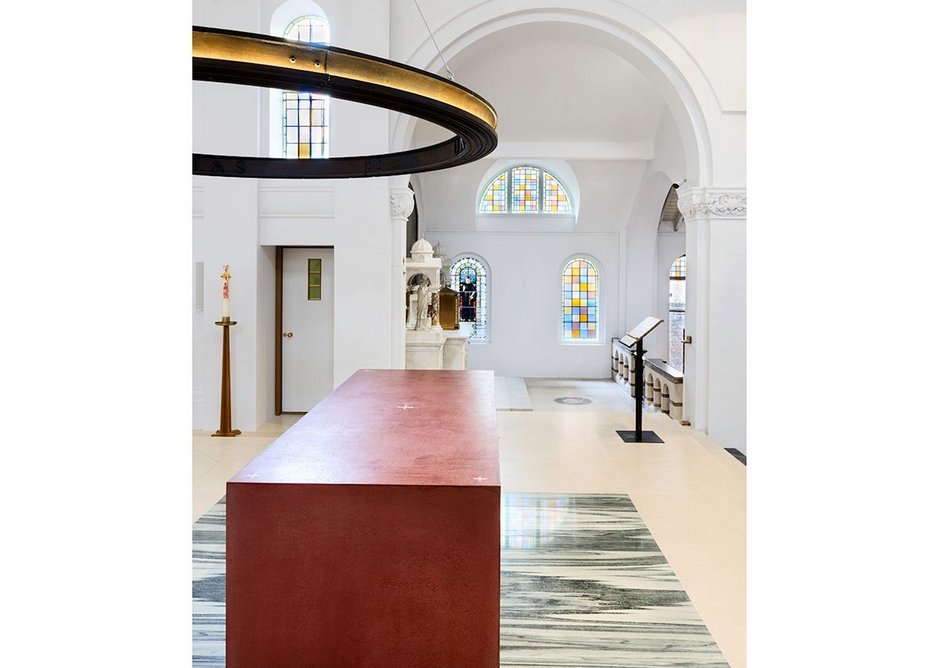 A red, Venetian plaster altar, by acclaimed ceramicist Julian Stair is the focal point of the church, below Barr’s cast iron ring of light. They sit on top of re-used green marble from the previous high altar.