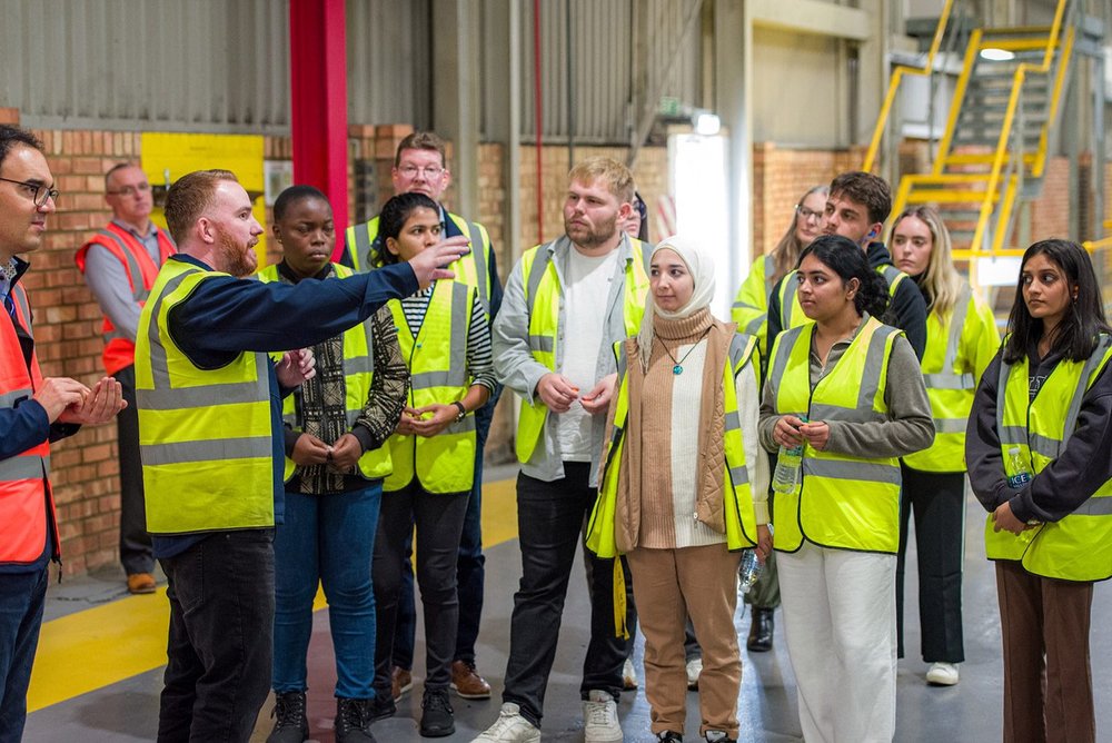 James Curson, plant manager at Ravago, shows students around the factory.