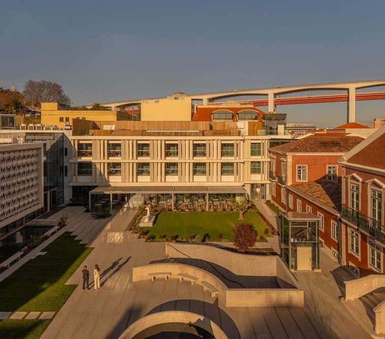 The 25 de Abril Bridge rises behind MACAM's central courtyard.