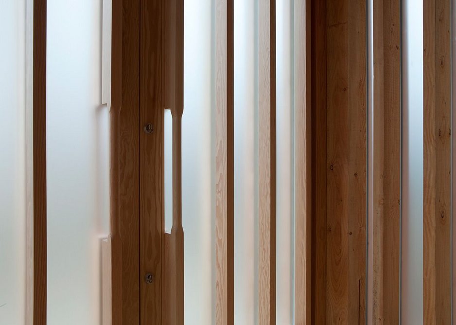 Detail of integral wooden door handle within the glazed ribbed panels at the entrance of the chapel.