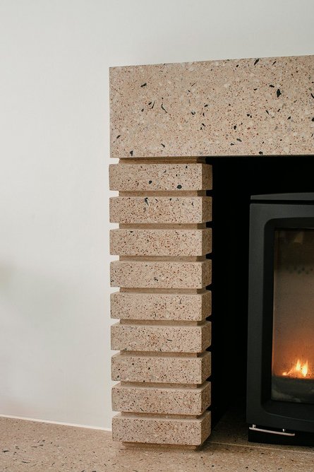 The fireplace replicates the exterior precast concrete exterior design.