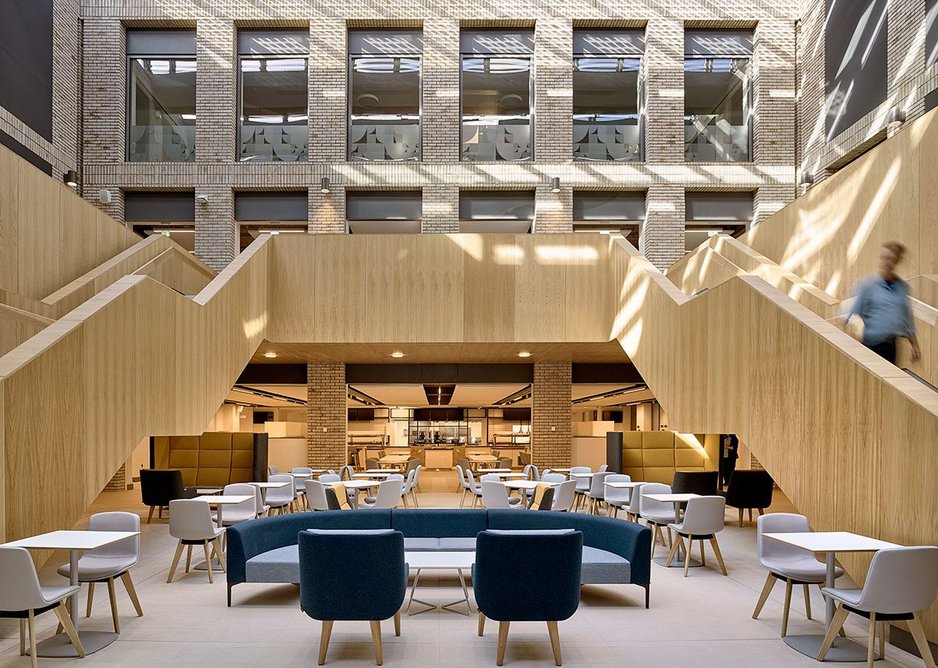 One of the implied planning blocks is removed to make the atrium court, lined with brick, with timber-clad stairs and with a café at its base. Photovoltaics also provide shading.