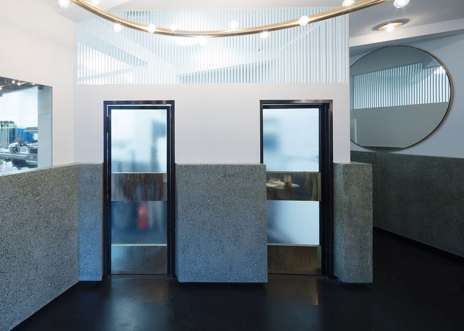 Dark screed floors and green terrazzo, glass, brass, walnut and mirror make up a materially rich palette.