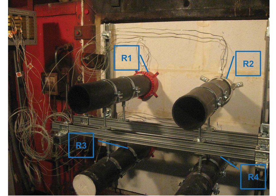 The specimen set up, before igniting the furnace, clearly showing pipes, firestop collars and thermocouples.