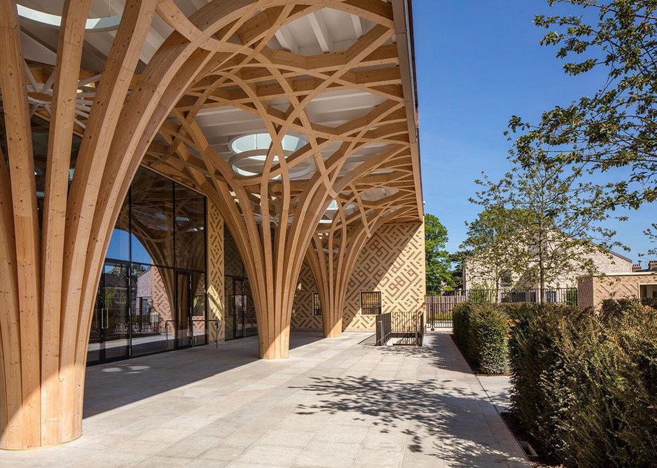 A colonnade of structural timber columns supports a portico which is the first experience of the building from the street.