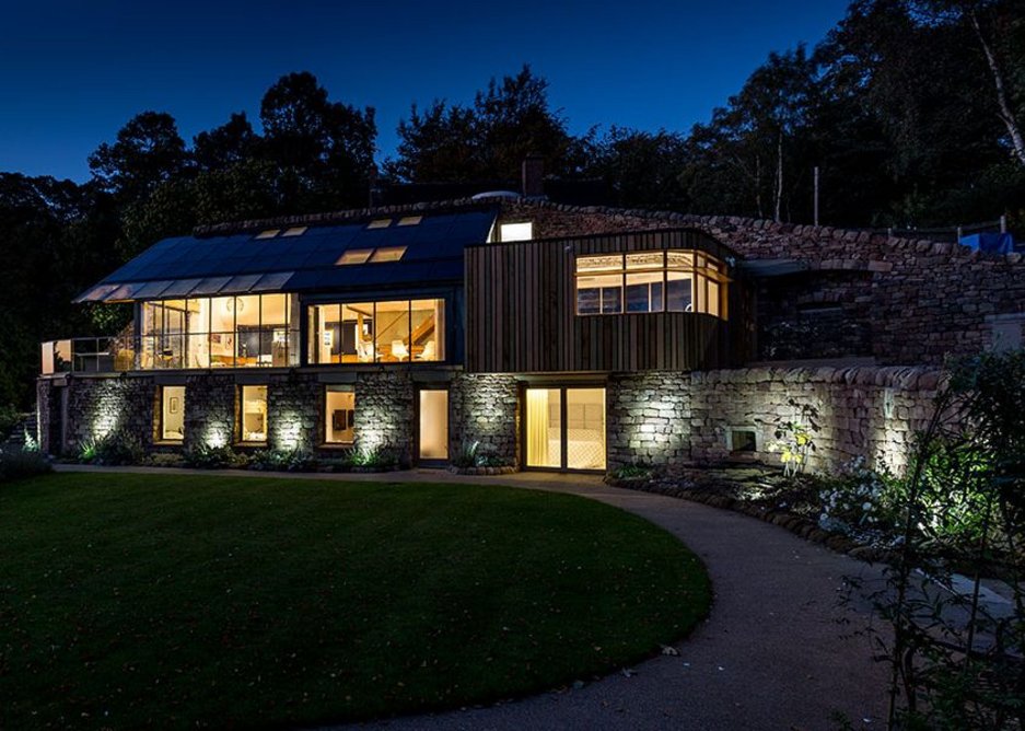 Dusk shot reveals the arrangement of a substantial but self-effacing house.