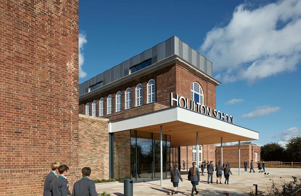 The main south entrance with a steel gate beyond leading to the external courtyard space, opened daily when pupils arrive and leave.