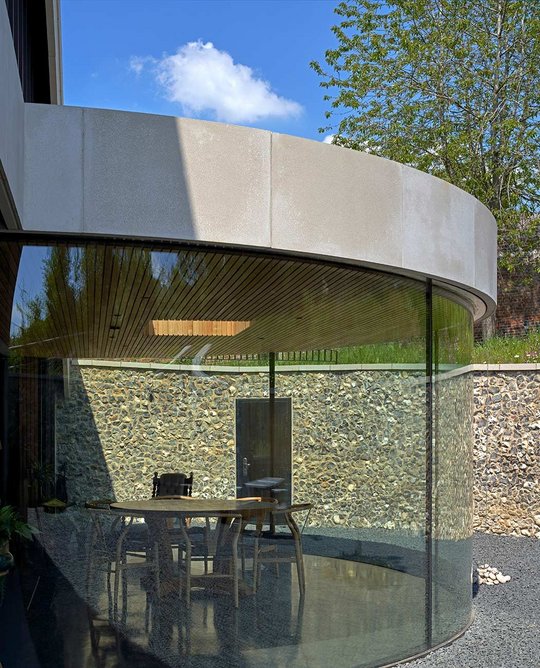 The Portland stone panels create a sleek border to complement the tones of the surrounding flint wall.
