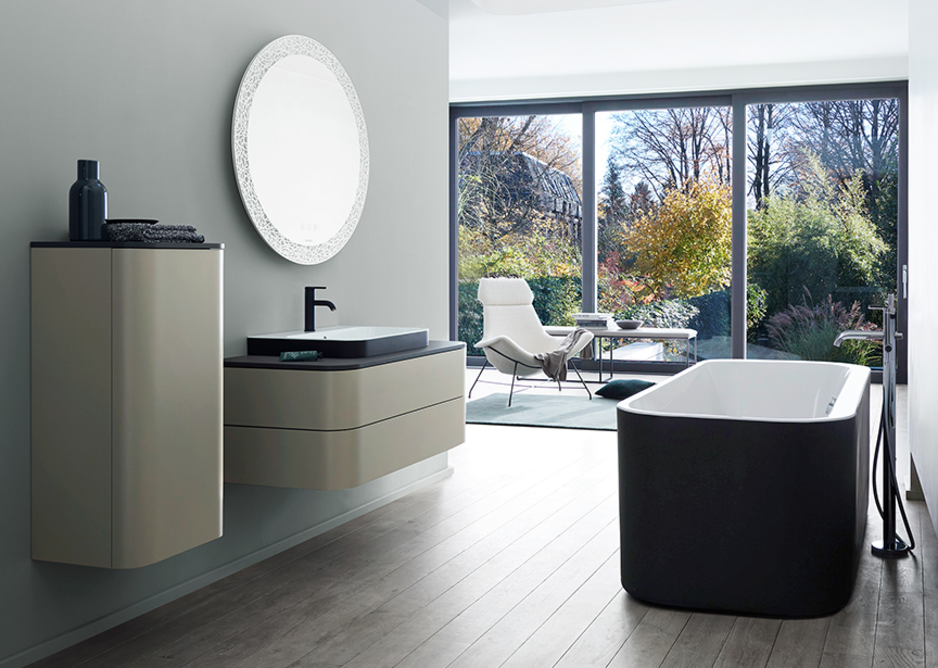 The circle and open oval geometric elements that typify the design are supported by the two-tone colouring of the above-the-counter basins in Anthracite Matt/White and the bathtub with external panelling in Graphite Super Matt.