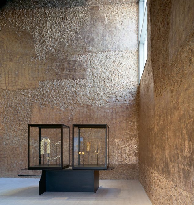 High windows light a 7m-high gallery whose plaster walls are finished in reflective silver leaf that will patinate in the humid climate. Minimal black steel display cases were designed by Holtrop.