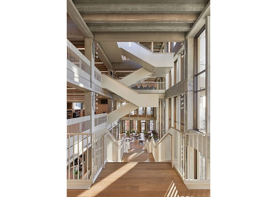 At third floor the concrete staircases along the façade switches to a condensed, steel dogleg staircase. Stage lights bring columns to light on darker days.
