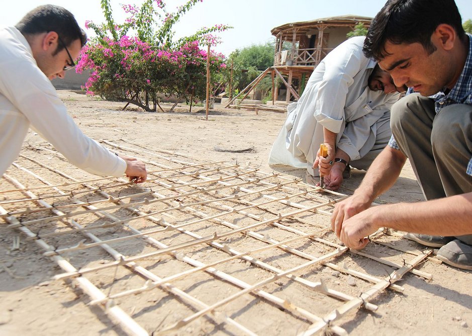 Students make a bamboo lattice for the corners and the walls of the Yasmeen Lari-designed house, to prevent damage during earthquakes.