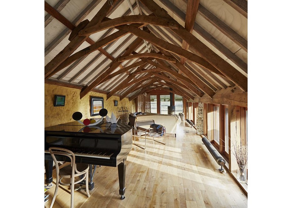 The elevated living room takes advantage of the beautiful roof trusses, new and old.