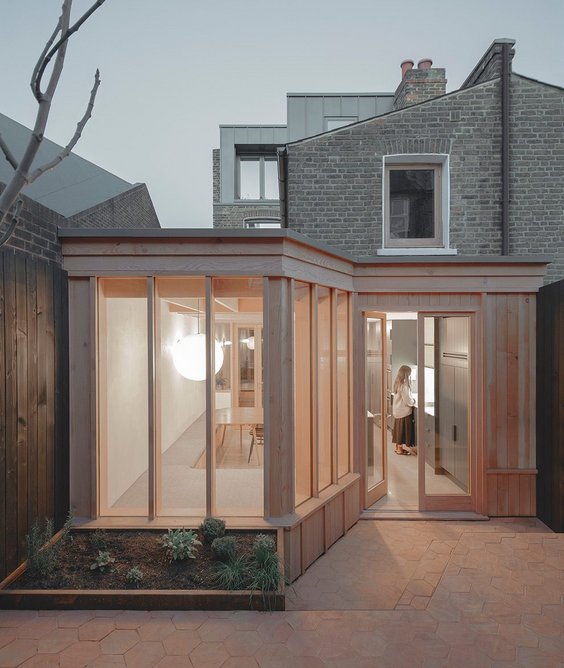 Earthy terracotta tiles in the back garden complement the colour and grain of the Douglas fir.