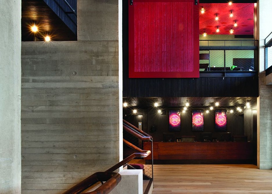 Overlooking the foyer is an events room which can be closed off: the sliding screen is made of lengths of timber used in the concrete shuttering.