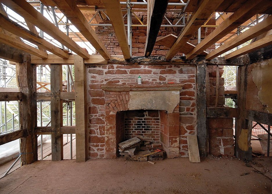 Timber beams, old and new, starting to be put back into place.