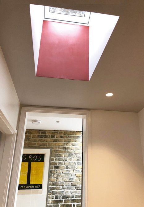 Toplight from a VELUX roof window is warmed by reflection on a painted surface.